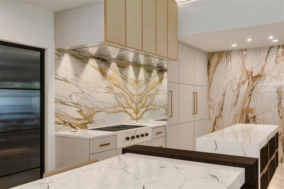 Veined porcelain backsplash and range with brass accents, Pellyn Wood renovation
