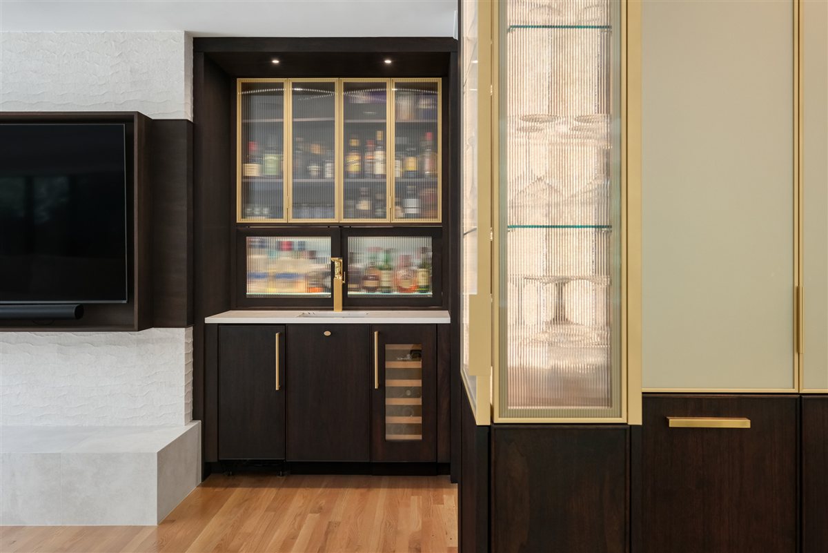Dark wood bar with glass-front cabinets and a lit display, Pellyn Wood renovation