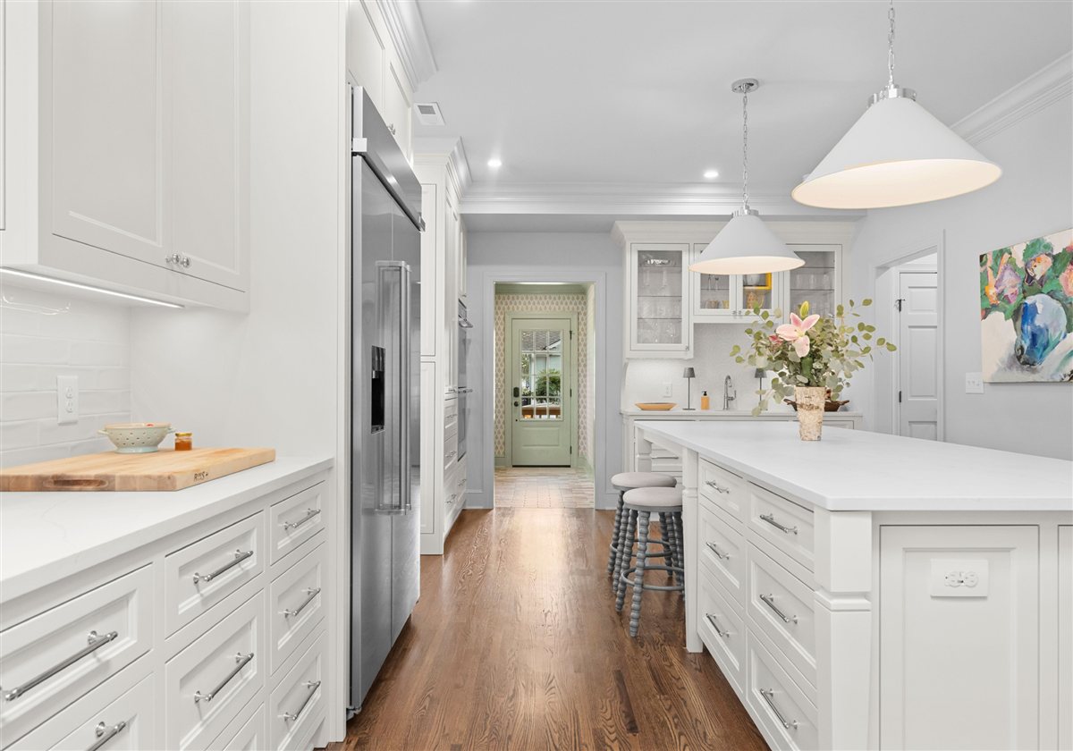 White kitchen with a quartz-topped island and pendant lights, Providence Park historic home addition