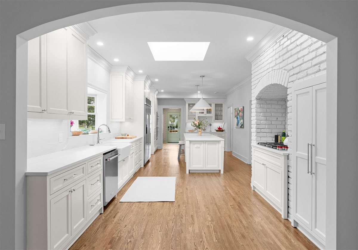 Kitchen framed by an arched opening with a skylight, Providence Park historic home