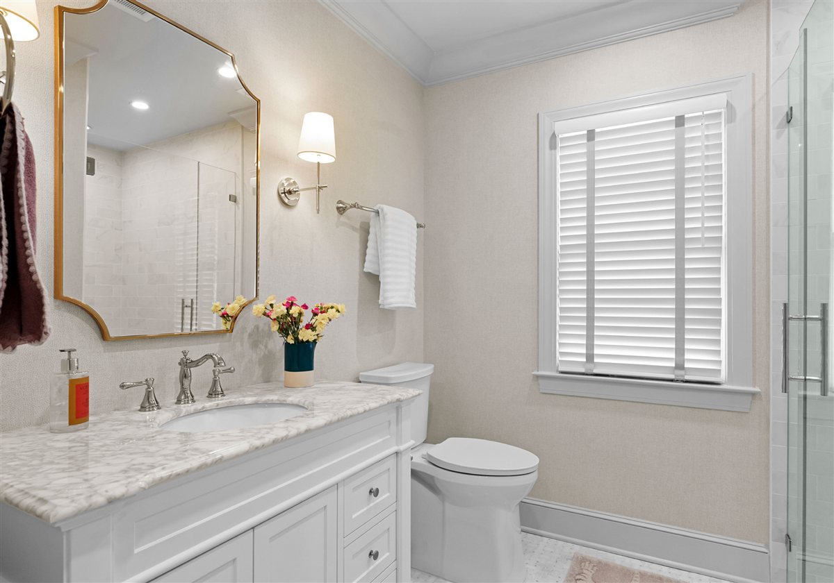 Bath vanity with a gold mirror and white countertop, Providence Park historic home