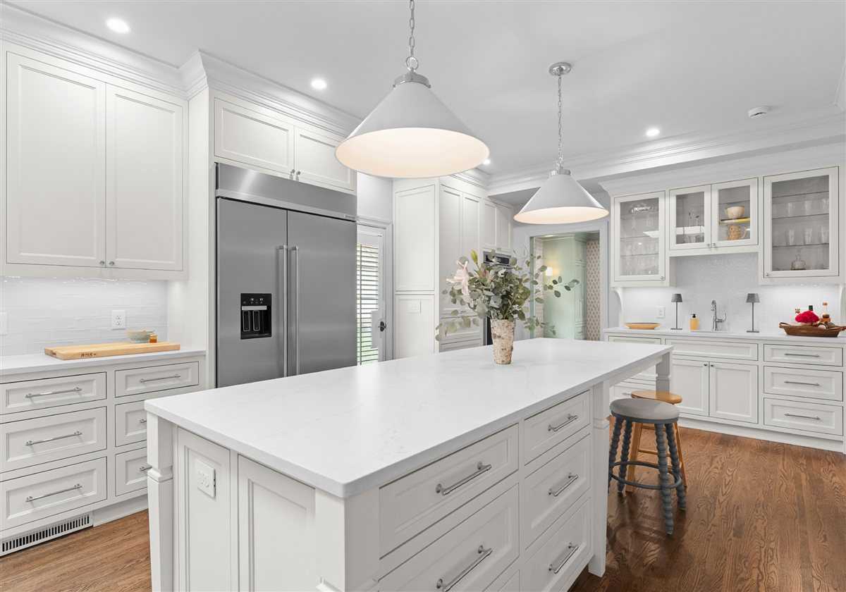 Kitchen island with stools and a stainless refrigerator, Providence Park historic home
