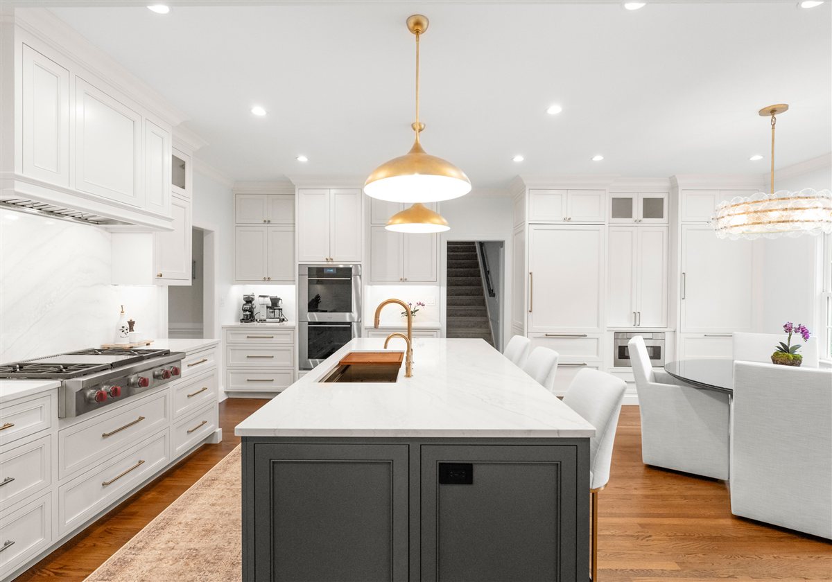 Charcoal island with a brass pendant and white cabinetry, Providence Plantation kitchen