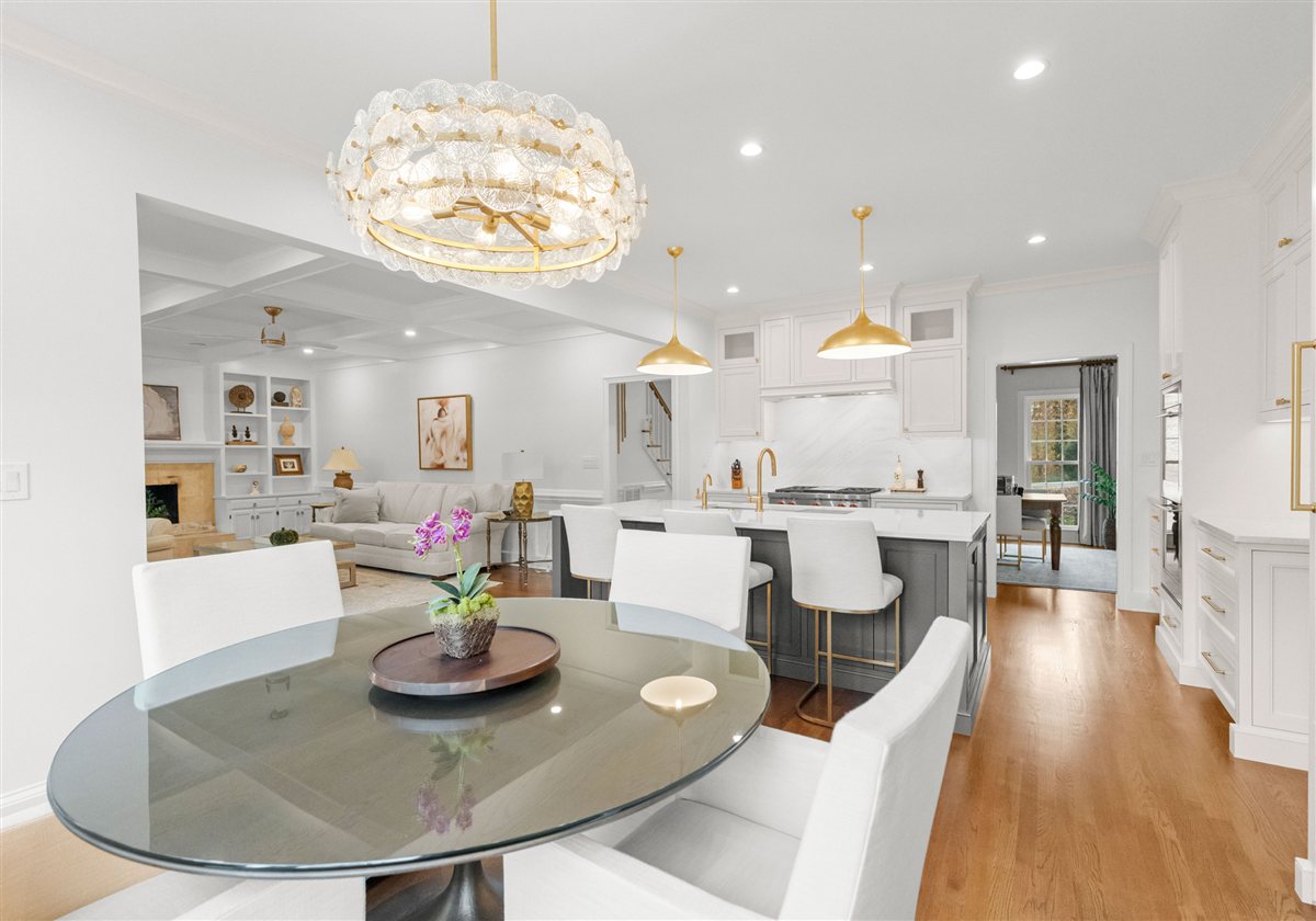 Glass breakfast table and white chairs under a crystal chandelier, Providence Plantation kitchen