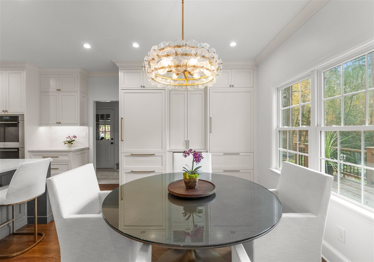 Breakfast area with a round glass table and white cabinetry, Providence Plantation kitchen