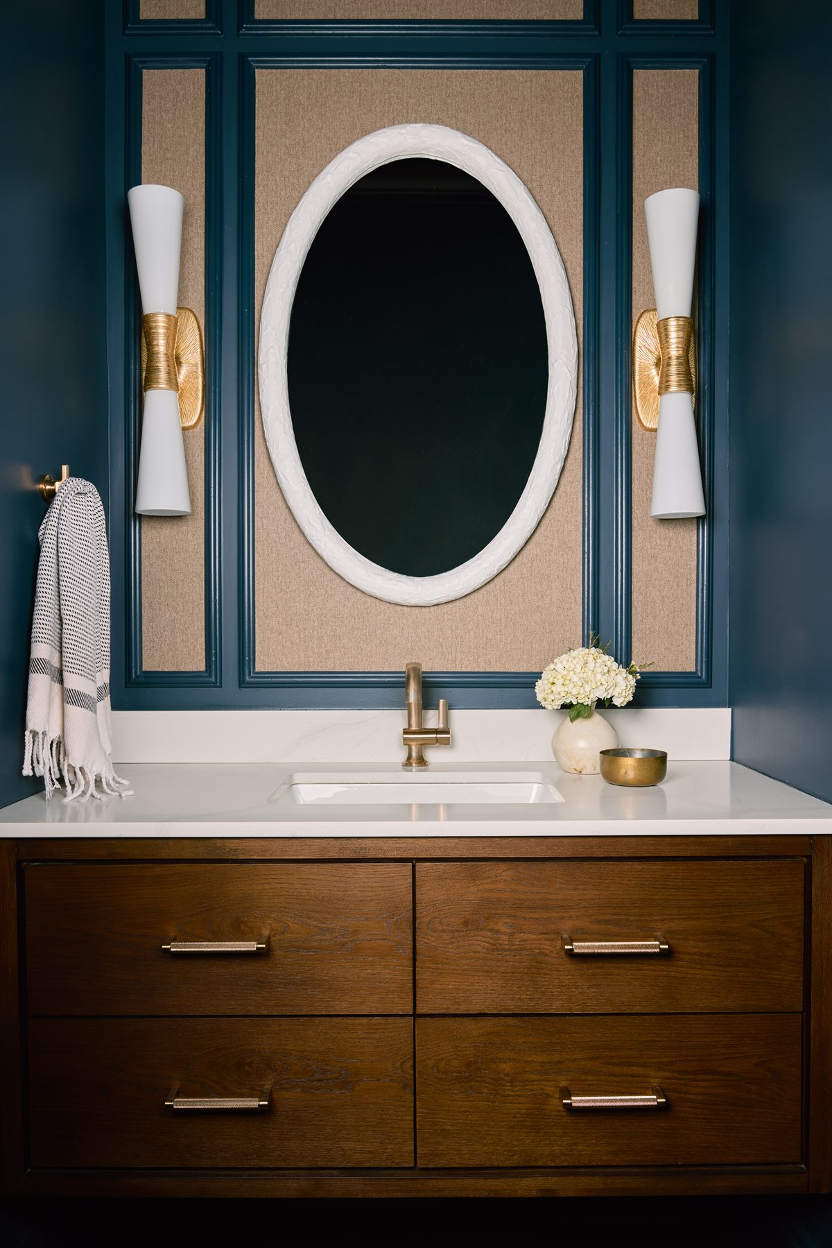 Powder bath with a floating wood vanity, oval mirror, navy panel molding and brass sconces, Providence Springs, Charlotte