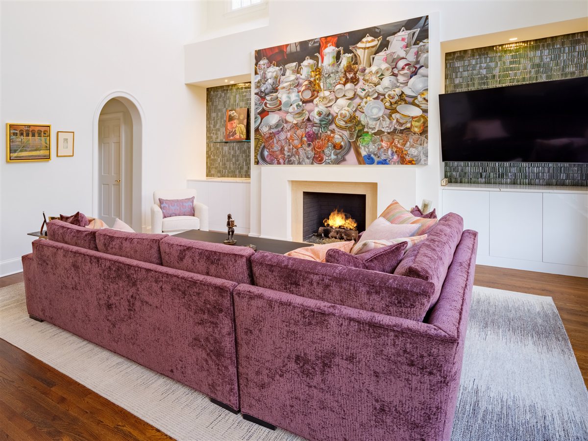 Living room with a velvet sectional, fireplace and large artwork, SouthPark renovation