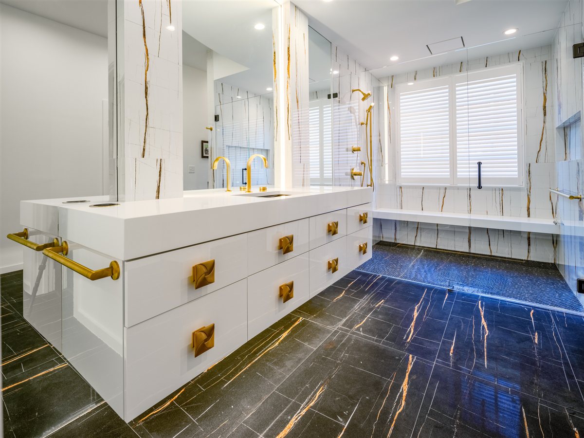 Primary bath vanity with brass hardware and a dark veined floor, SouthPark renovation