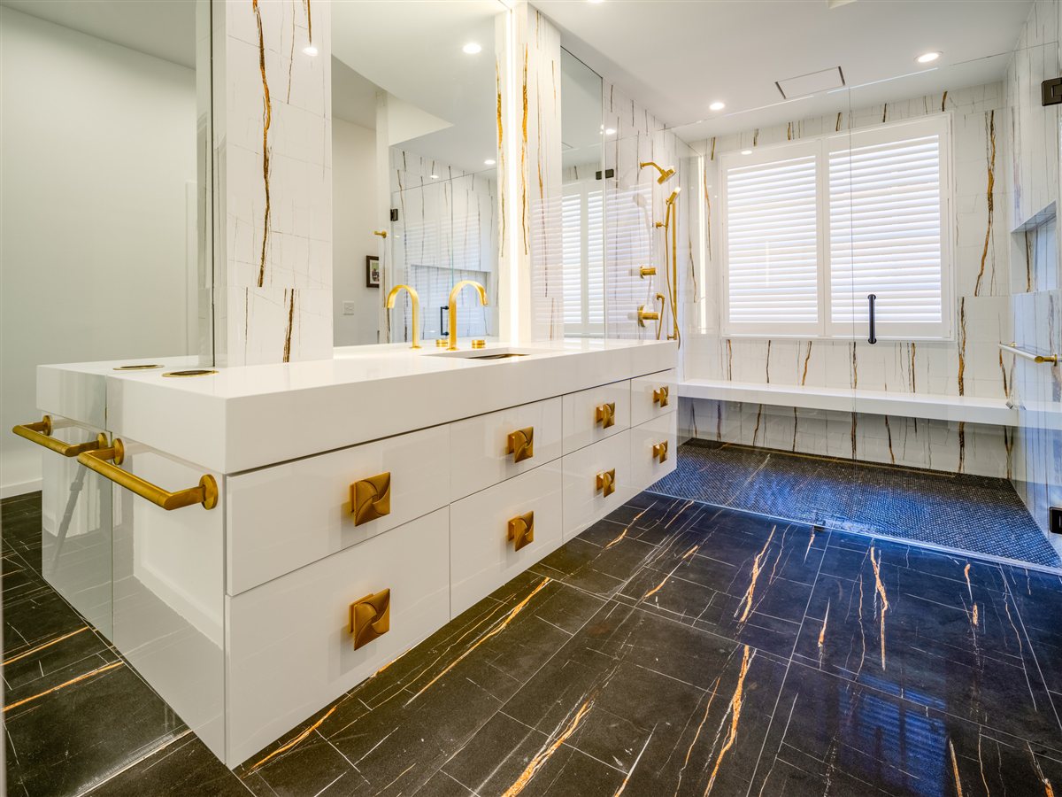 Bath vanity with brass pulls and a dark stone-look floor, SouthPark renovation