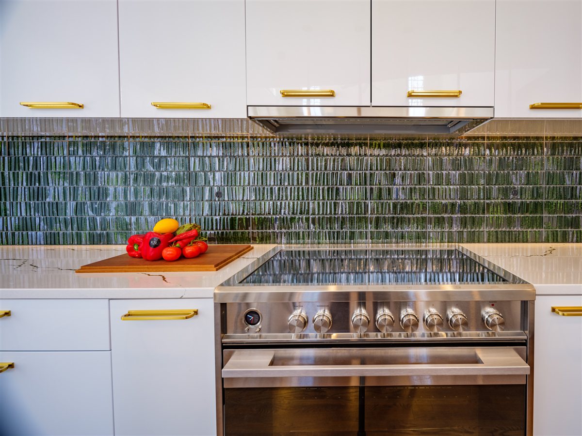 Stainless range beneath a green glazed tile backsplash, SouthPark kitchen