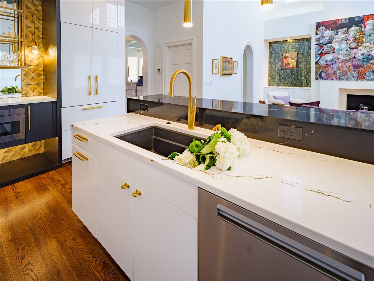 Sink with a brass faucet along a black countertop, SouthPark kitchen