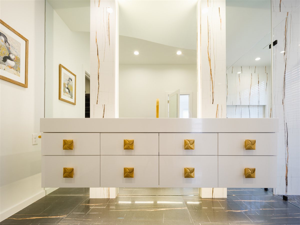 Floating vanity with brass pulls beneath a large mirror, SouthPark renovation