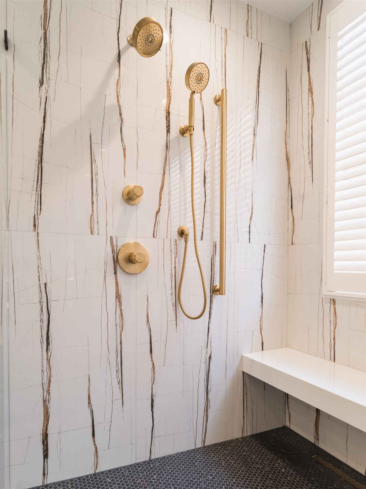 Shower wall with a brass hand shower, SouthPark renovation