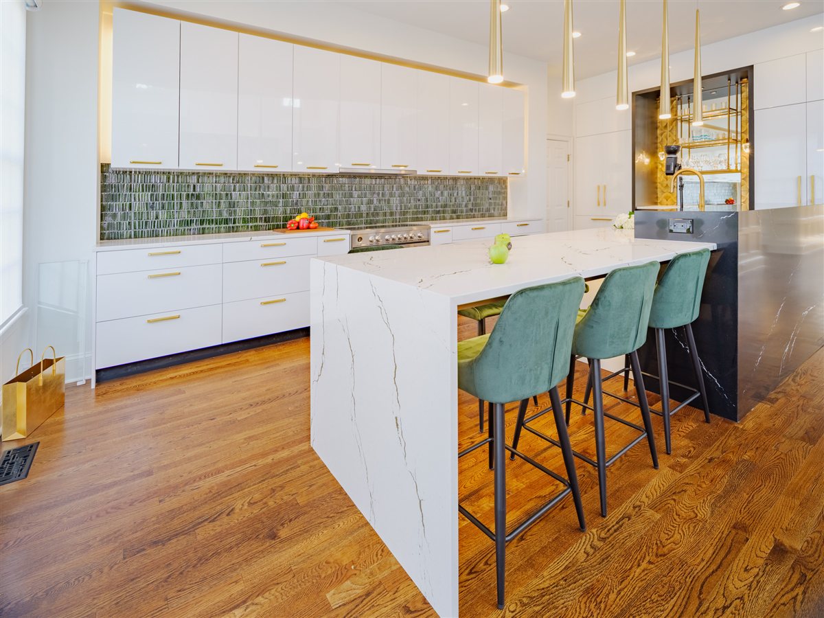 Quartz waterfall island with teal stools and gold pendants, SouthPark kitchen