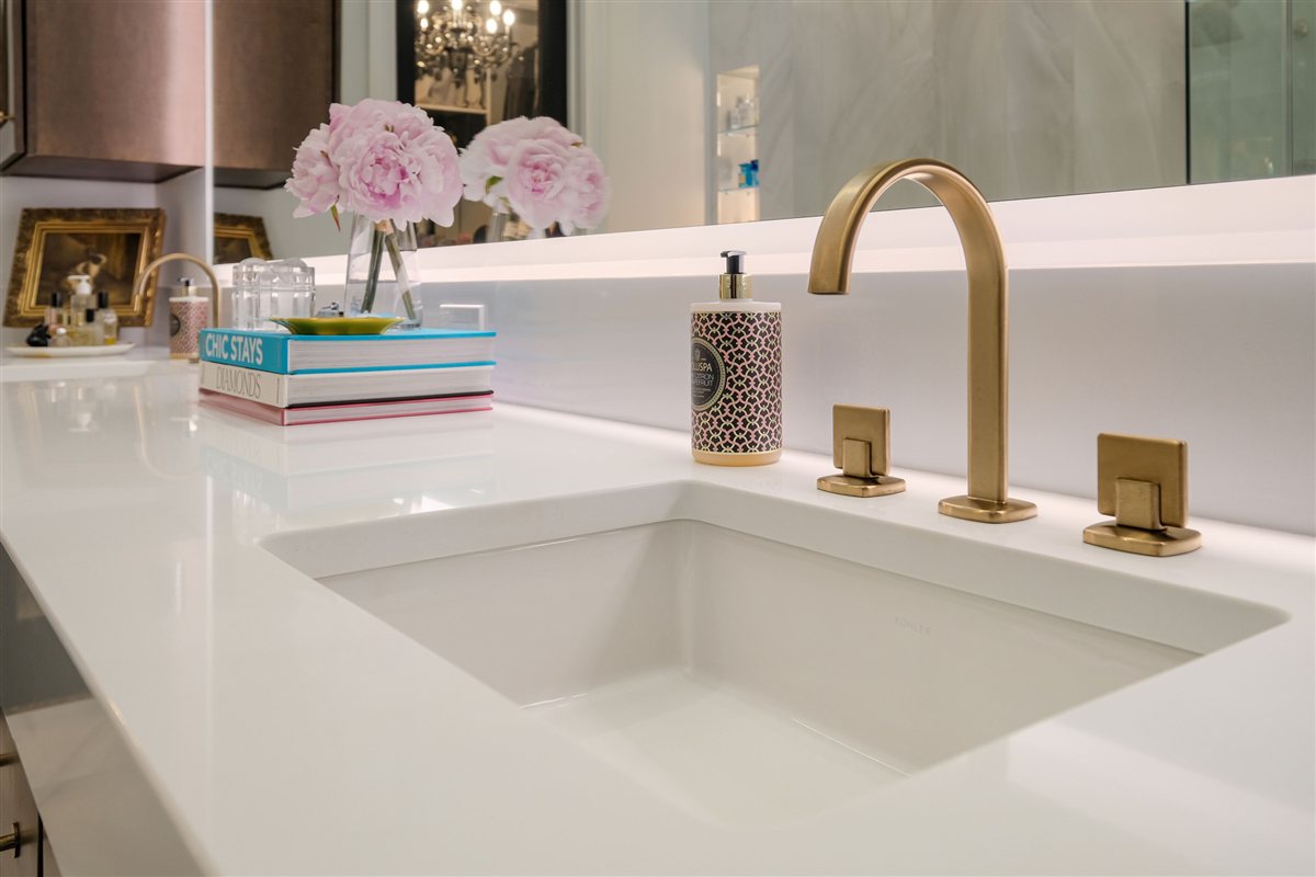 Brass faucet at an undermount sink with a white countertop, Uptown primary suite