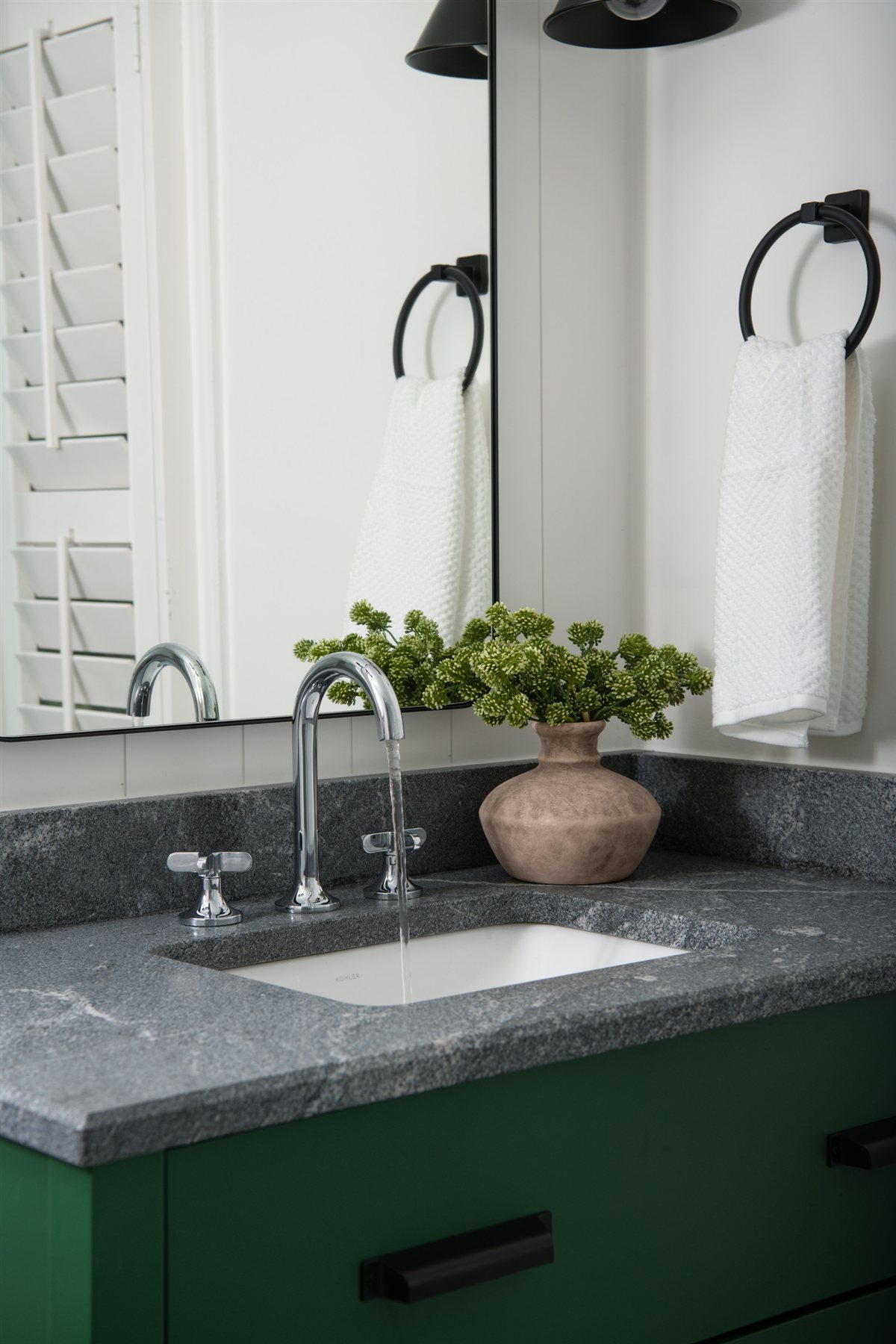 Bath vanity with a wall-mounted faucet and round mirror, Valencia Terrace renovation