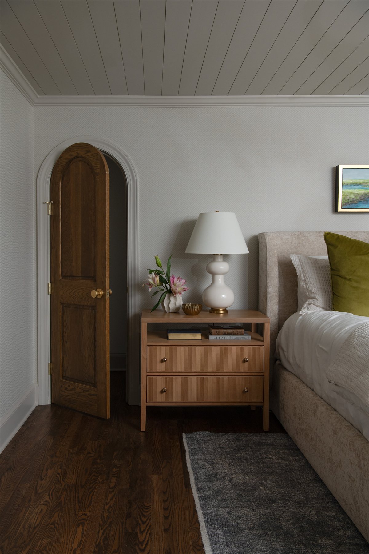 Primary bedroom corner with an arched door and bench, Valencia Terrace addition