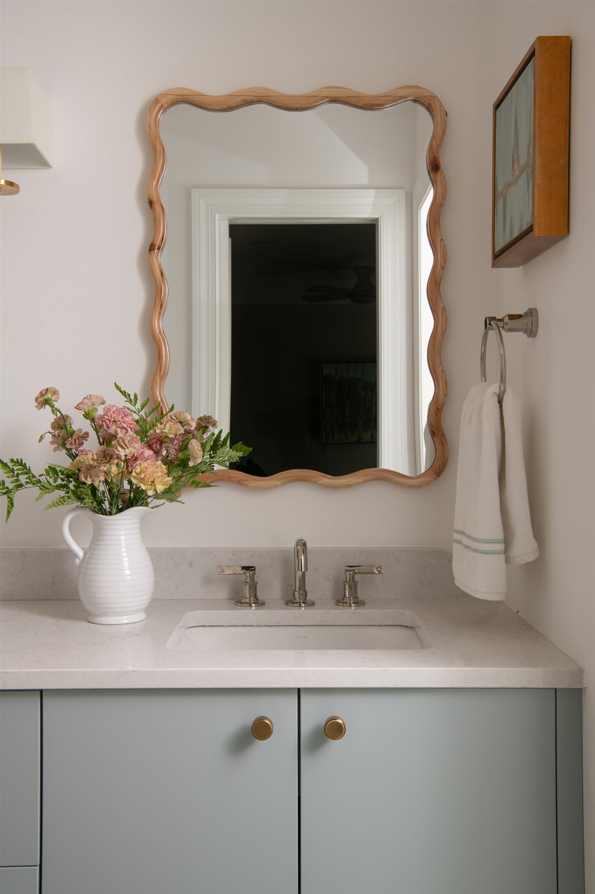 Powder room with a scalloped mirror and pale blue vanity, Valencia Terrace renovation