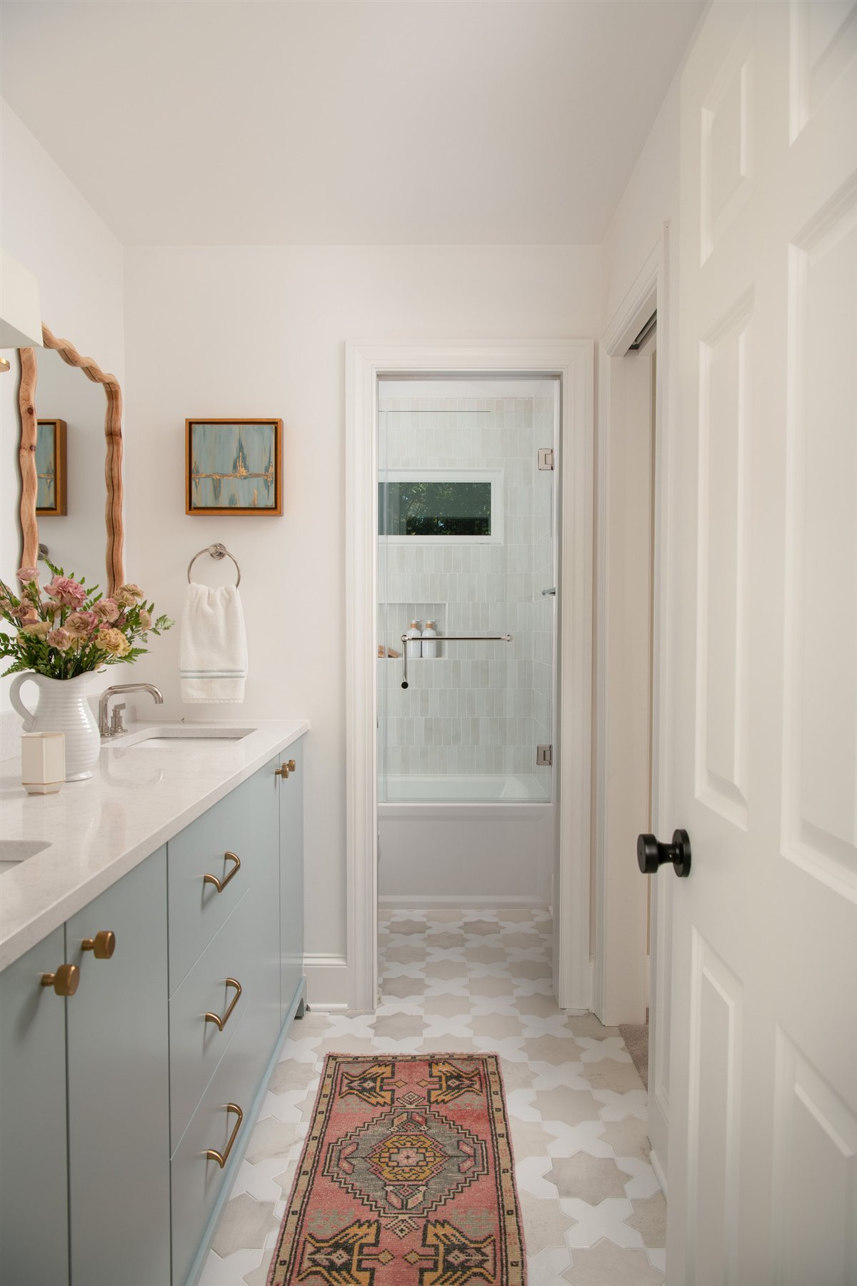 Hall bath vanity in pale blue with brass sconces, Valencia Terrace renovation