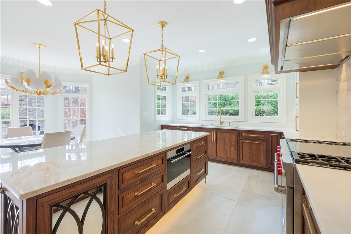 Quartzite island and brass lanterns beside the window wall, Waxhaw kitchen
