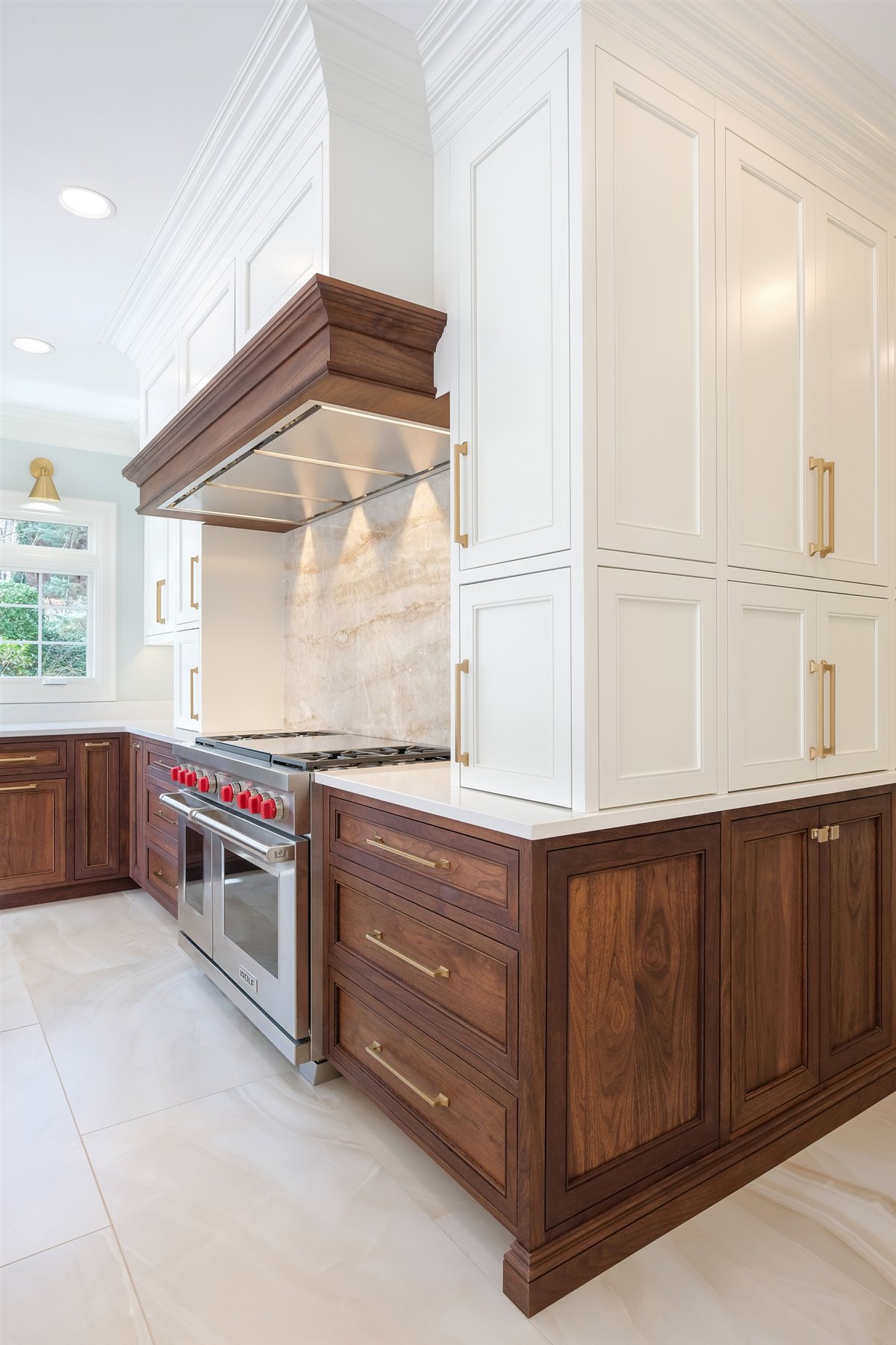 Range wall with a full-height Taj Mahal quartzite backsplash and wood hood, Waxhaw kitchen