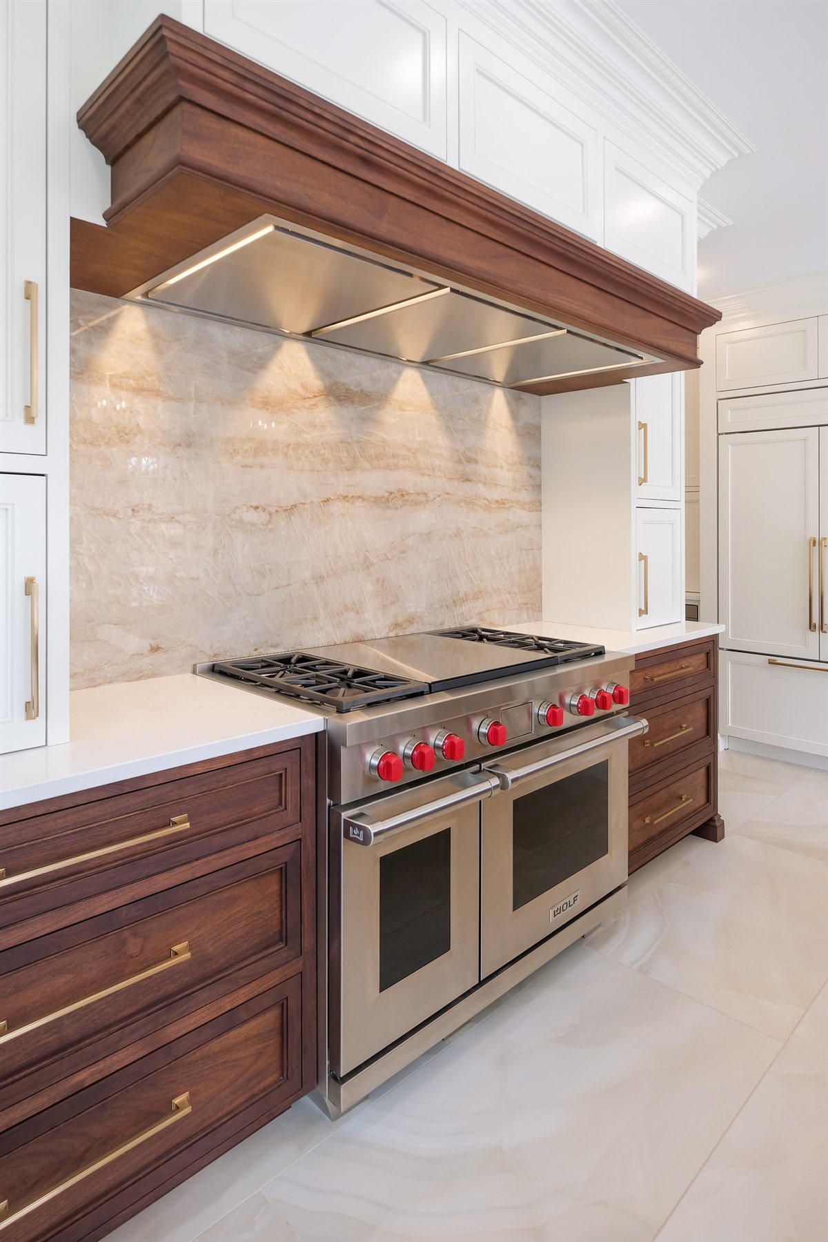 Professional range with red knobs under a wood hood, Waxhaw kitchen