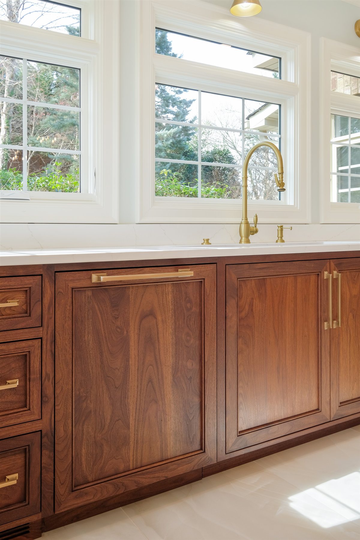 Walnut base cabinets beneath a row of windows, Waxhaw kitchen