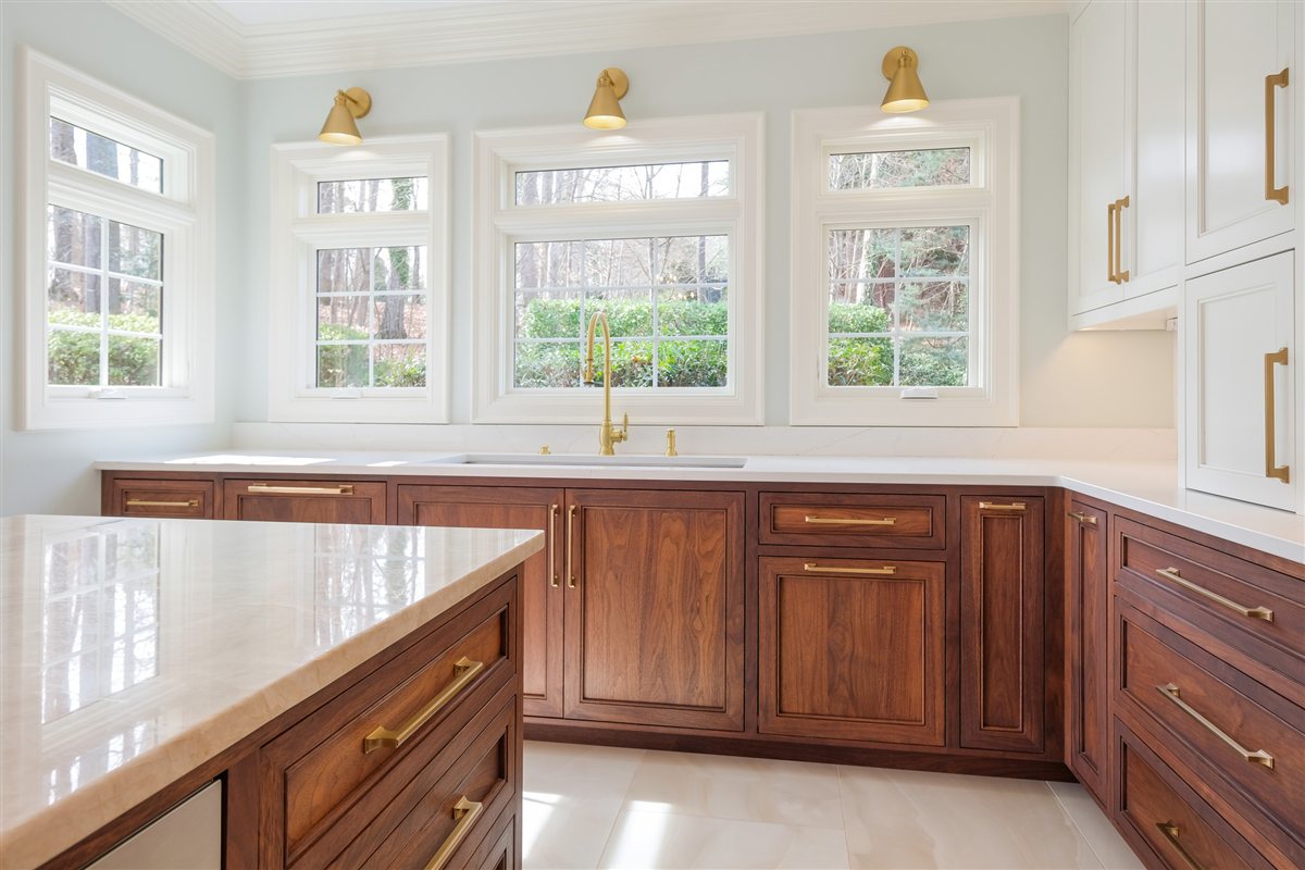Walnut perimeter cabinets and quartzite counters under windows, Waxhaw kitchen