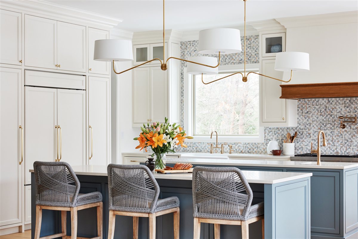 Kitchen island with woven stools under a modern chandelier, Waxhaw renovation