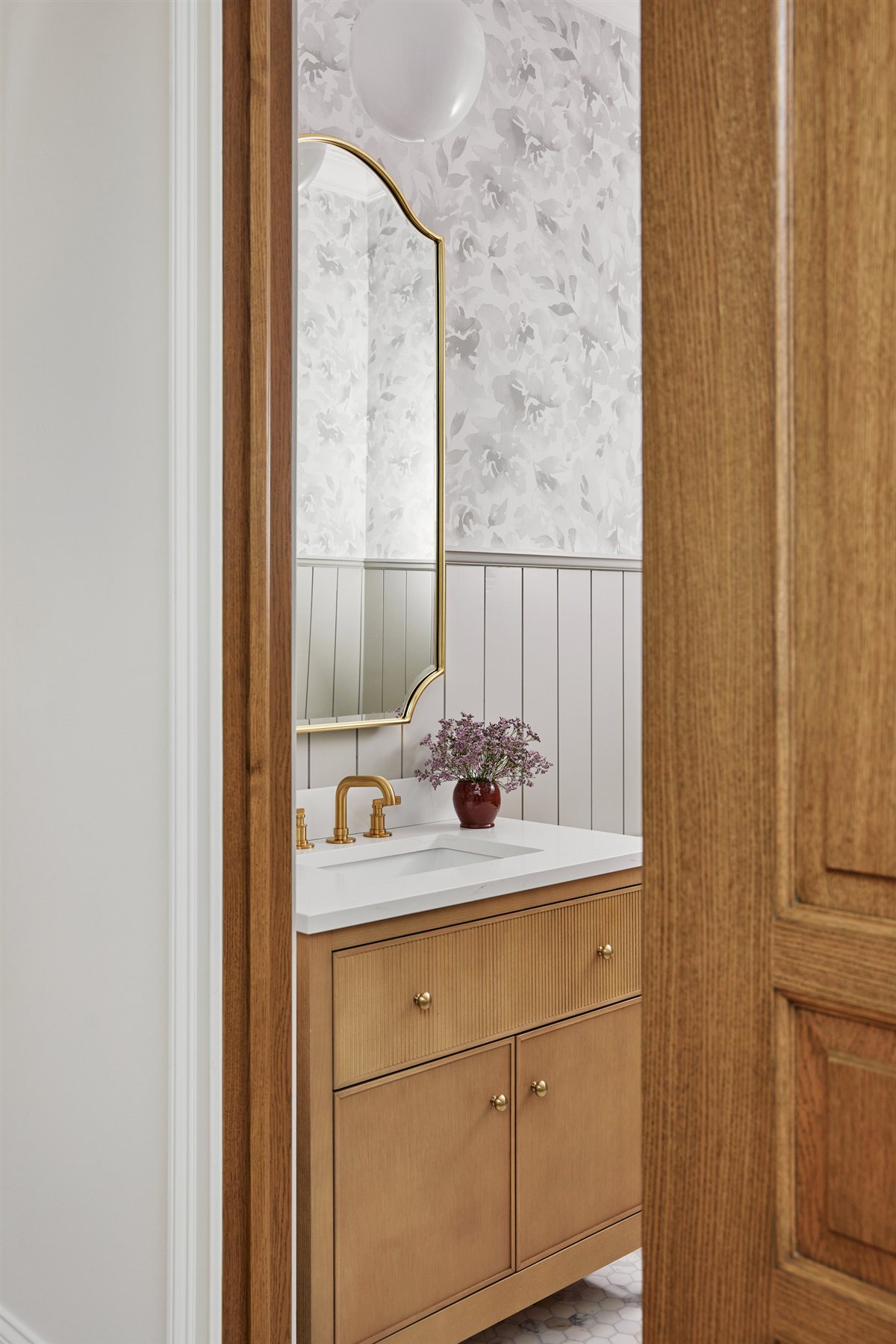 Powder room with a wood vanity and floral wallpaper, Waxhaw renovation
