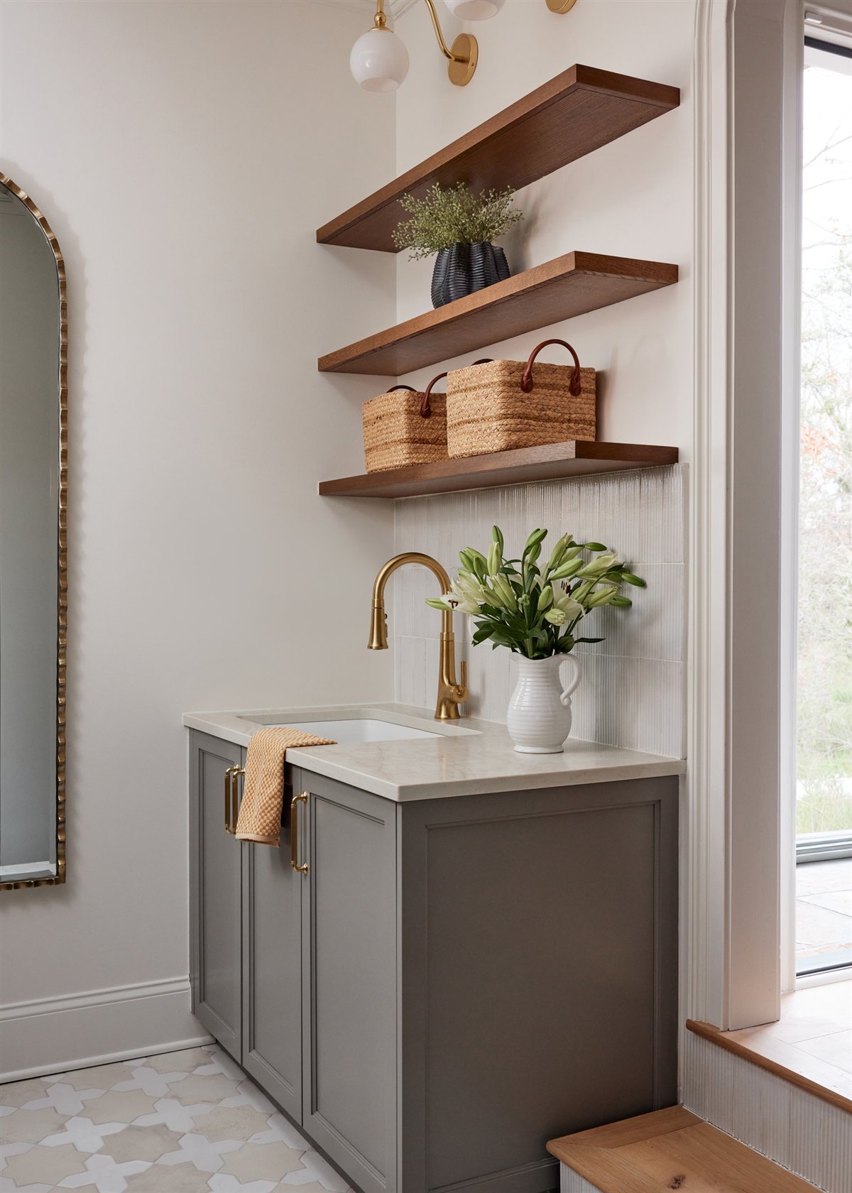 Laundry sink with a brass faucet and floating wood shelves, Waxhaw renovation