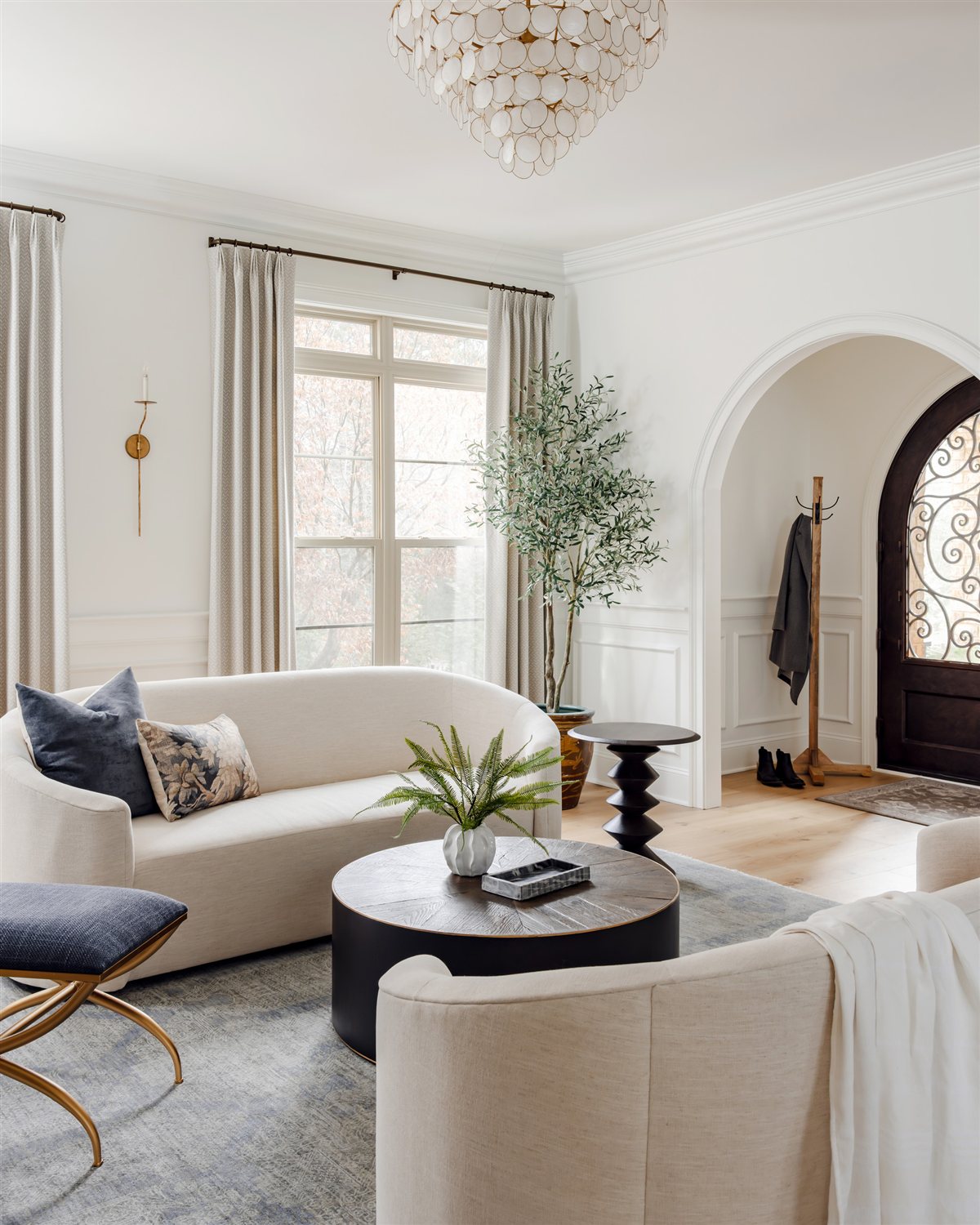 Living room with a round coffee table and linen drapery, Waxhaw renovation