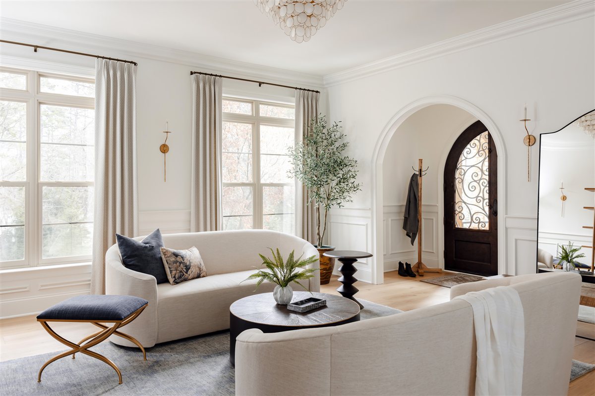 Living room with a curved sofa and a crystal chandelier, Waxhaw renovation