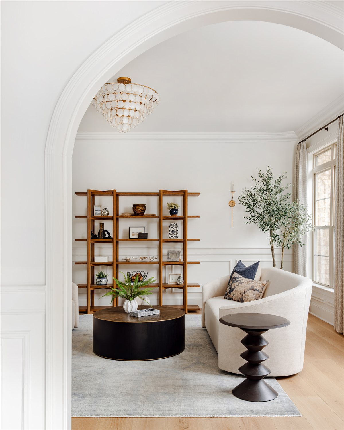 Reading nook with swivel chairs and open shelving beneath an arch, Waxhaw renovation